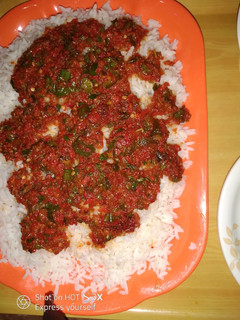 A picture of White rice with spinach sauce.