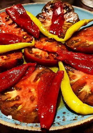 Una foto de Ensalada de tomate ibérico, pimiento asado dulce y piparras con sal de hierbas provenzales