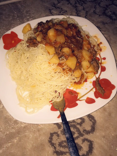 A picture of Spaghetti and shredded beef with potato soup.