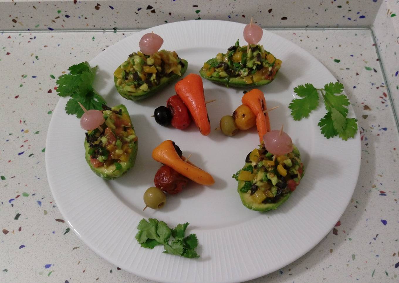 Aguacates rellenos de pimientitos y tomatitos de colores asados