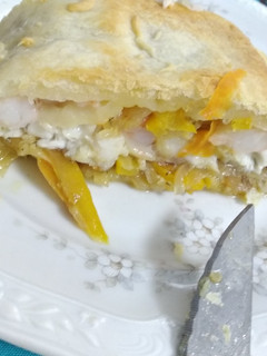 Una foto de Lubina al Wellington con verduras y gambas