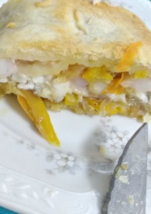 Una foto de Lubina al Wellington con verduras y gambas