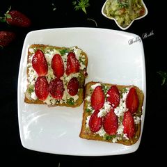 A picture of Cheesy guacamole strawberry open sandwich.