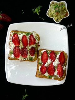 A picture of Cheesy guacamole strawberry open sandwich.