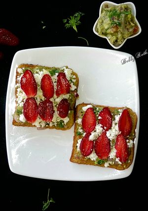 A picture of Cheesy guacamole strawberry open sandwich.