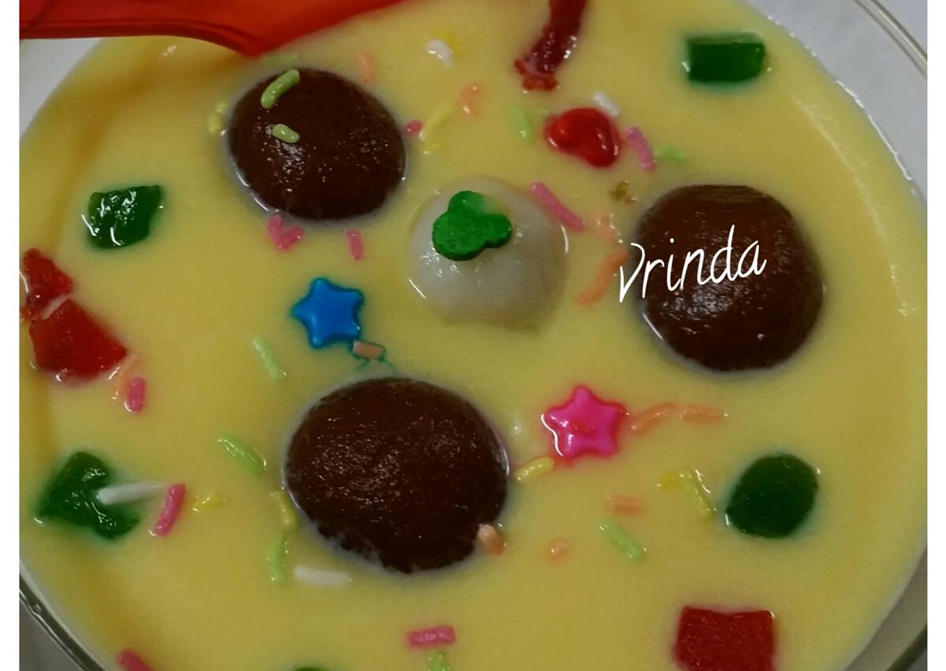 Gulab jamun floating in custard sauce