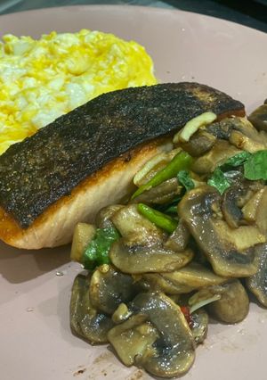 A picture of Grilled salmon with stir-fried mushroom with Thai basil.