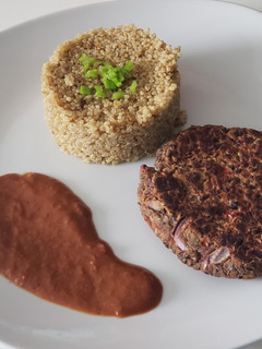 Una foto de Quinoa con hamburguesa de poroto negro y salsa de vino tinto