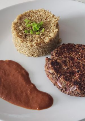 Una foto de Quinoa con hamburguesa de poroto negro y salsa de vino tinto
