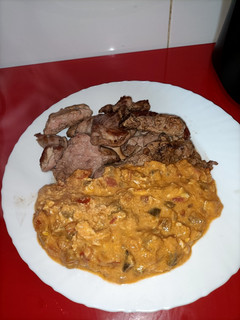 Una foto de Pisto revuelto con huevos y cabeza de lomo a la plancha