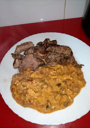 Una foto de Pisto revuelto con huevos y cabeza de lomo a la plancha