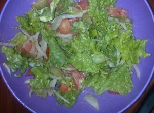 Una foto de Ensalada de tomate, lechuga, cebolla y pepinitos