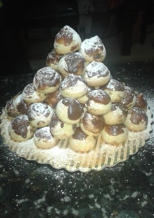 Una foto de Profiteroles rellenos de mermelada de fresa cubiertos con chocolate