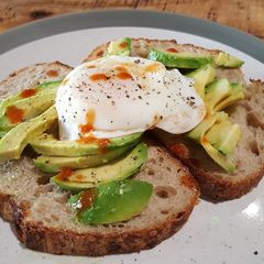 A picture of Soft poached egg and avocado on toasted sourdough.