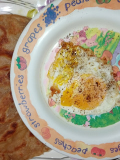 A picture of Wheat flour paratha with half fry egg.