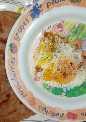 A picture of Wheat flour paratha with half fry egg.