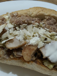 Una foto de Torta de chilaquiles verdes y rojos con milanesa de pollo y res