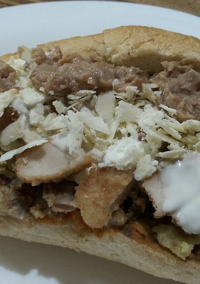 Una foto de Torta de chilaquiles verdes y rojos con milanesa de pollo y res
