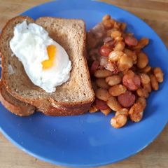A picture of Poached Egg served with baked beans.