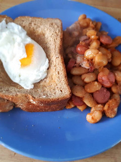 A picture of Poached Egg served with baked beans.
