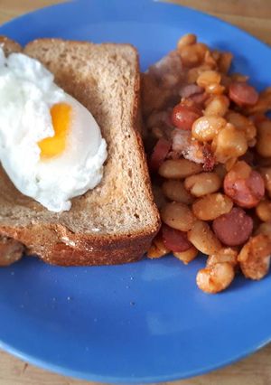 A picture of Poached Egg served with baked beans.