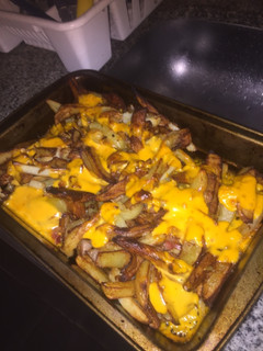 Una foto de Papas fritas con cheddar