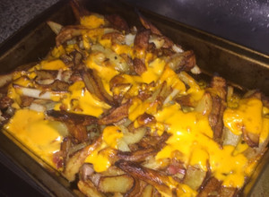 Una foto de Papas fritas con cheddar
