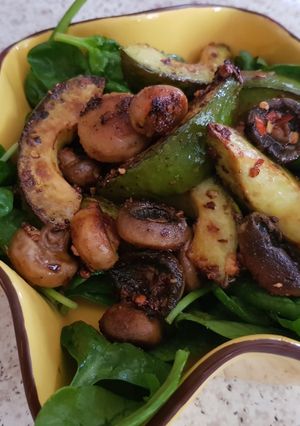 A picture of My Buttered Salt n pepper Mushroomson,Advocado on bed of Spinach.