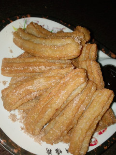 A picture of Cinnamon churros and cinnamon chocolate sauce.