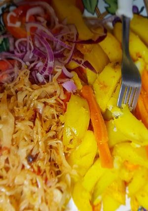 A picture of Roast potatoes, carrots served with cabbage and kachumbari.