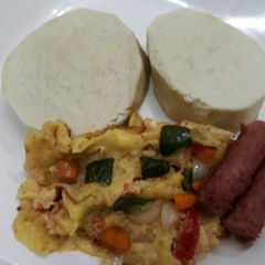 A picture of Boiled yam with fried eggs and sausages.