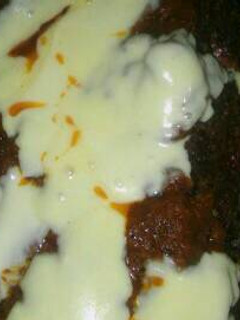 Una foto de Pan de carne relleno con salsa y queso arriba