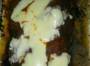 Una foto de Pan de carne relleno con salsa y queso arriba
