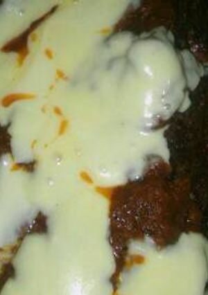 Una foto de Pan de carne relleno con salsa y queso arriba