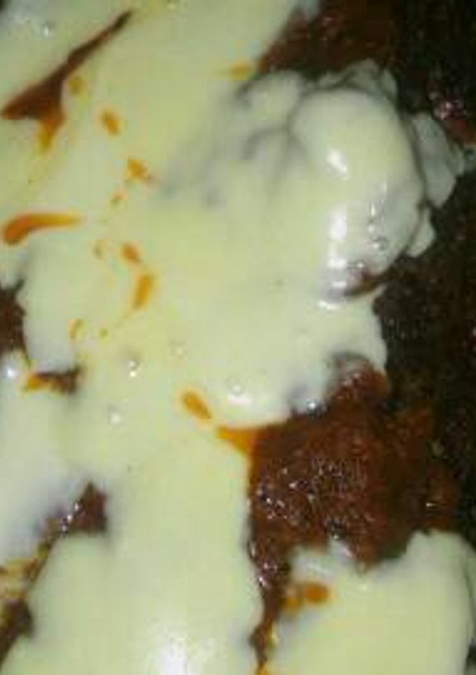 Una foto de Pan de carne relleno con salsa y queso arriba
