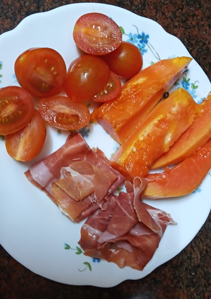 Una foto de Desayuno tropical: Papaya con jamón serrano y tomate cherry