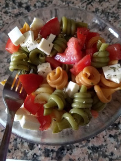 Una foto de Pasta tricolor con tomate, queso y orégano