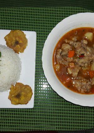Una foto de Cocido de patica de cerdo con arroz blanco y plátano frito