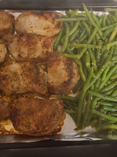 A picture of Pork chops with apples and green beans.