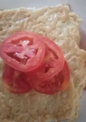 A picture of Heavy omelette with tomato slices.