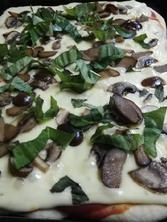 Una foto de Pizza de champiñón, aceitunas y albahaca🍕