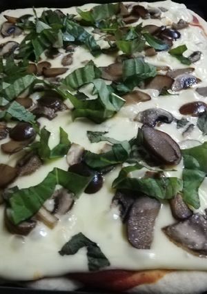 Una foto de Pizza de champiñón, aceitunas y albahaca🍕