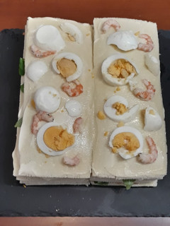 Una foto de Pastel frío de salmón, gambas y rúcula con mahonesa