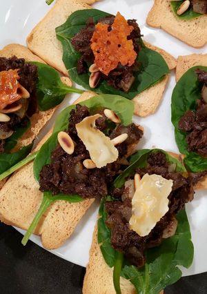 Foto principal de Tostas de morcilla, peras, piñones y queso gratinado