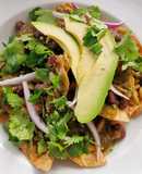 Chilaquiles con elote asado, frijoles negros y pepitas