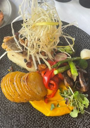 Una foto de Lomo de bacalao sobre romesco con patatas panadera y verduritas asadas