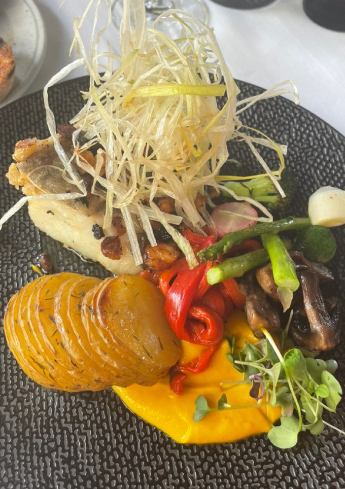 Una foto de Lomo de bacalao sobre romesco con patatas panadera y verduritas asadas