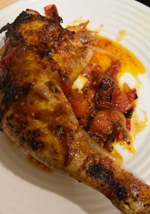 Una foto de Contramuslos de pollo jugosos con cebolla y tomate Cherry en airfryer