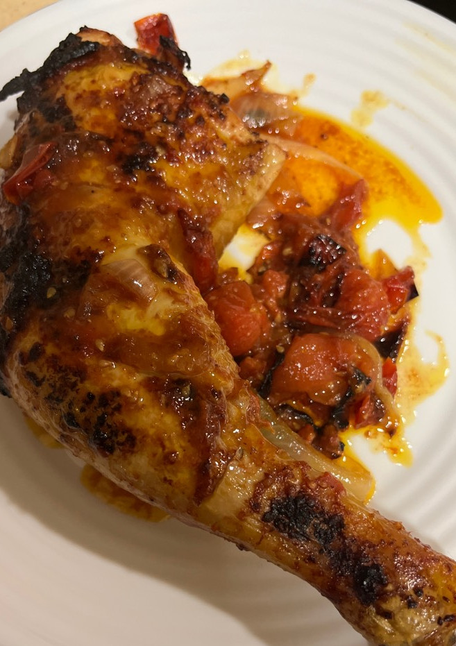 Una foto de Contramuslos de pollo jugosos con cebolla y tomate Cherry en airfryer