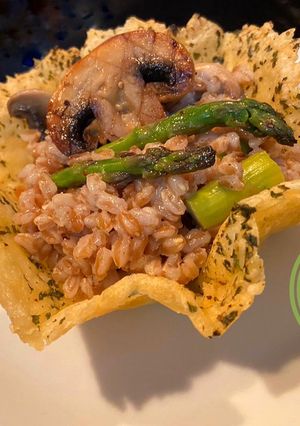 Una foto de Farro con hongos y espárragos